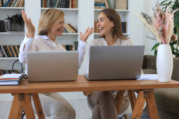 istock Two female collegues working with laptop and discussing new project. 1264844589