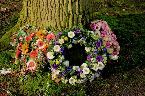 Sympathy wreath or funeral flowers near a tree