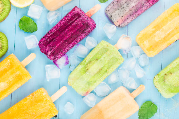 istock Various fruit popsicles are placed on the blue wooden board background, kiwi popsicles, orange popsicles, dragon fruit popsicles, cantaloupe popsicle 1264847219