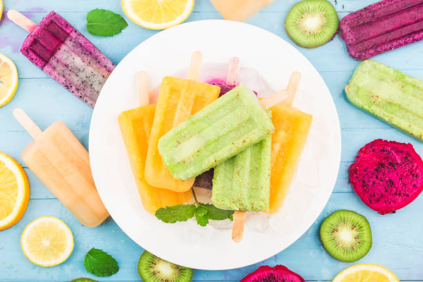 istock Various fruit popsicles are placed on the blue wooden board background, kiwi popsicles, orange popsicles, dragon fruit popsicles, cantaloupe popsicle 1264848128