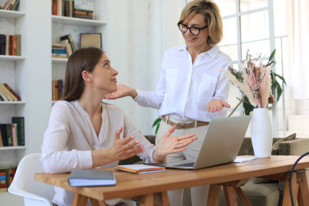 istock Two female collegues working with laptop and discussing new project. 1264848299