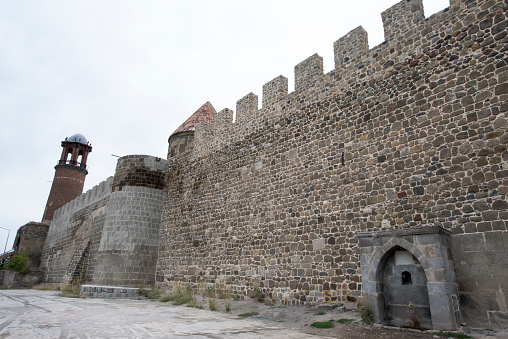Castle of Erzurum - Erzurum, Turkey - August 30 2019:  Exterior view of Tray Minaret or Clock tower and castle wall.