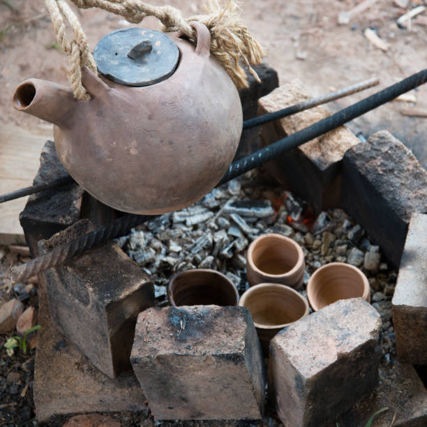 istock A steaming teapot and tea cups. Tea preparation in a clay pot on a fire. A camping trip, a journey. 1264852149