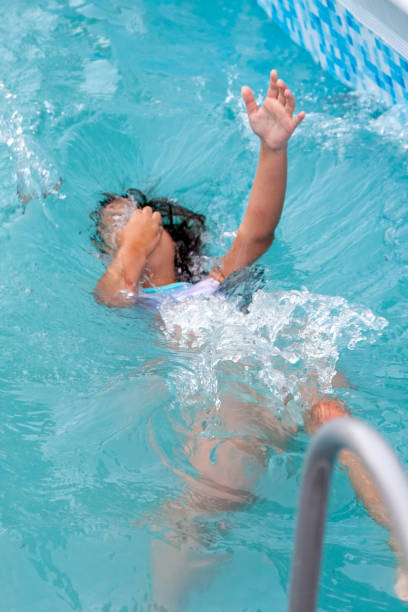 istock Child girl falls into the pool 1264852192