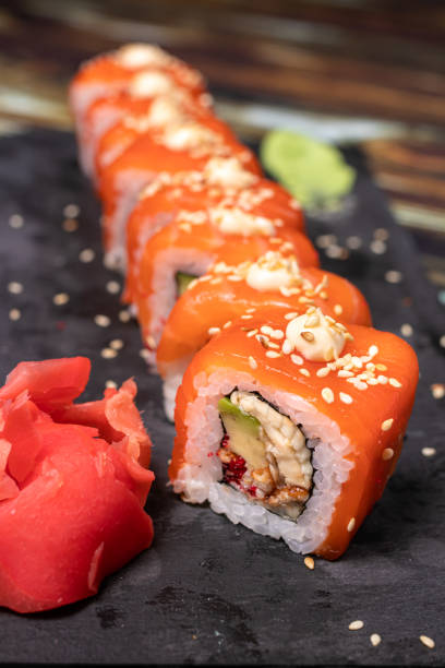 istock Sushi with salmon and rice with sesame seeds on a black background. 1264854276