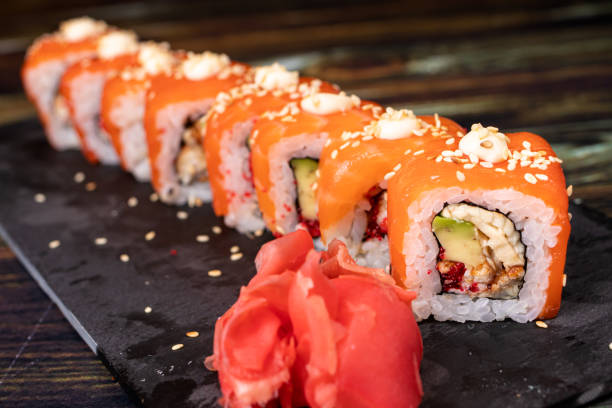istock Sushi with salmon and rice with sesame seeds on a black background. 1264854357