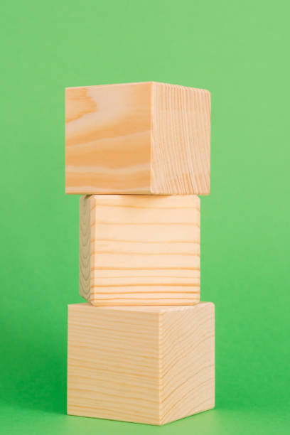 istock Construction of wooden cubes on green background with copy space. Mockup composition for design 1264854539