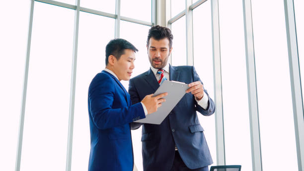 istock Two business people talk project strategy at office 1264860627