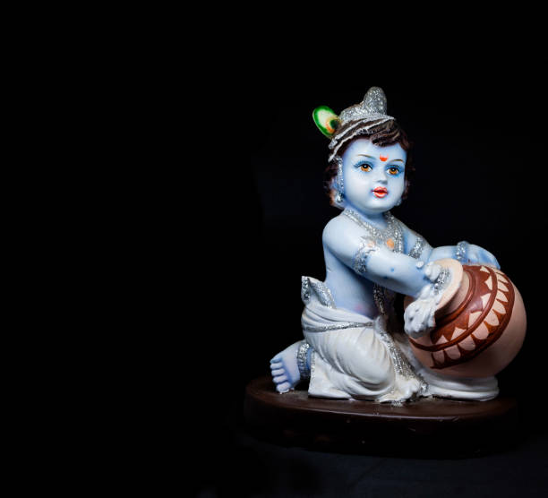 Cute and innocent idol of Hindu God Lord Krishna Cute and innocent idol of Hindu God Lord Krishna as a child eating butter. Celebrated during Janmashtami. Editable,banner,poster radha krishna stock pictures, royalty-free photos & images