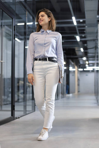 istock Businesswoman walking along the office corridor with documents. 1264862757