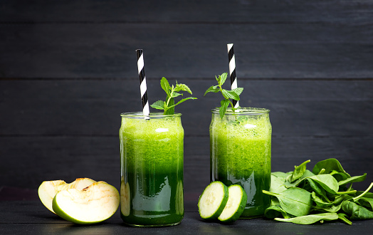 Prepared diet smoothie with cucumber apple and parsley and green vegetables in a glass. Detox healthy green with a large variety of fruits and vegetables