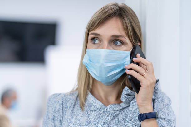 istock Businesswoman with protective face mask at work talking on phone, during COVID-19 1264864948