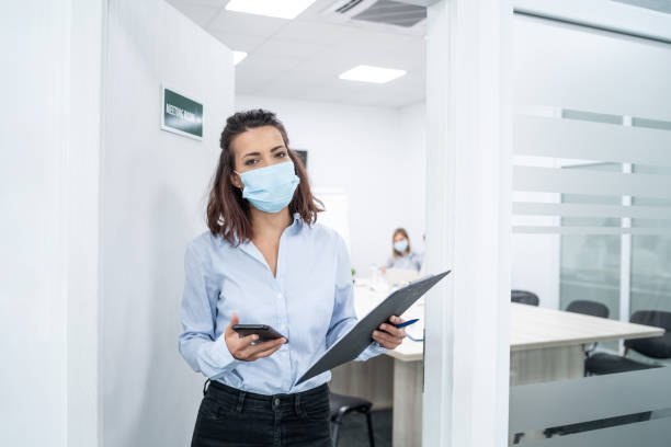 istock Businesswoman with protective face mask at work talking on phone, during COVID-19 1264864986