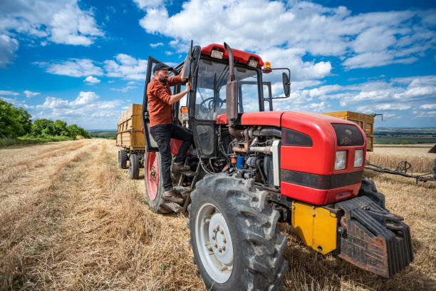 istock Farmer controlled harvest in his field and driving red tractor 1264865017