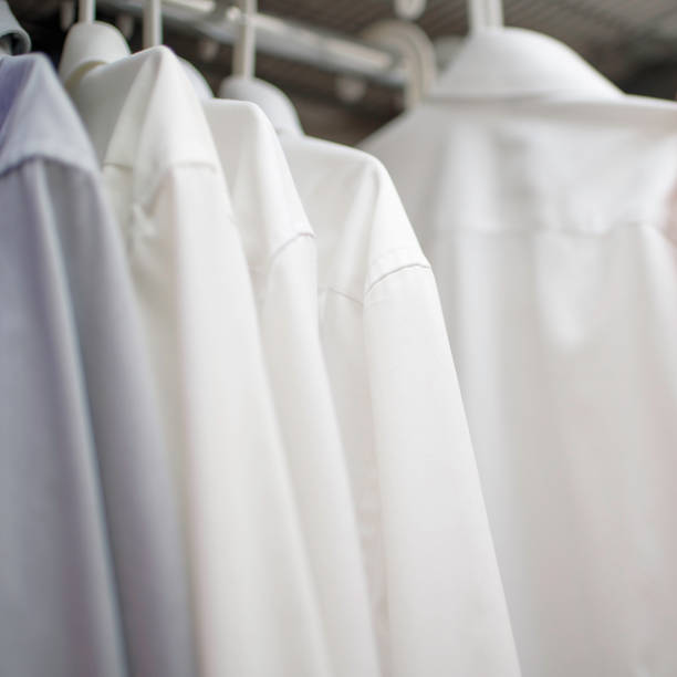 istock white men's shirts on hangers in wardrobe 1264866038