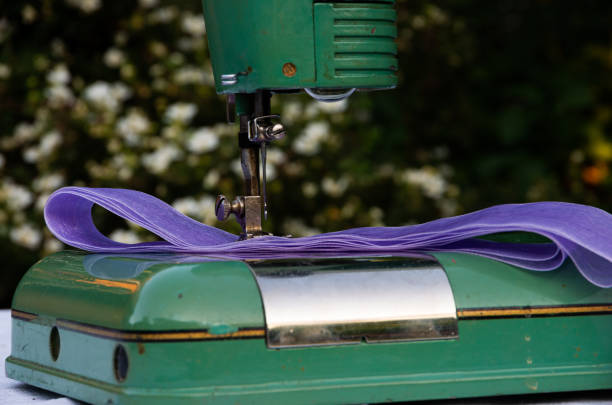 Green old, retro green sewing machine with purple fabric, finger job