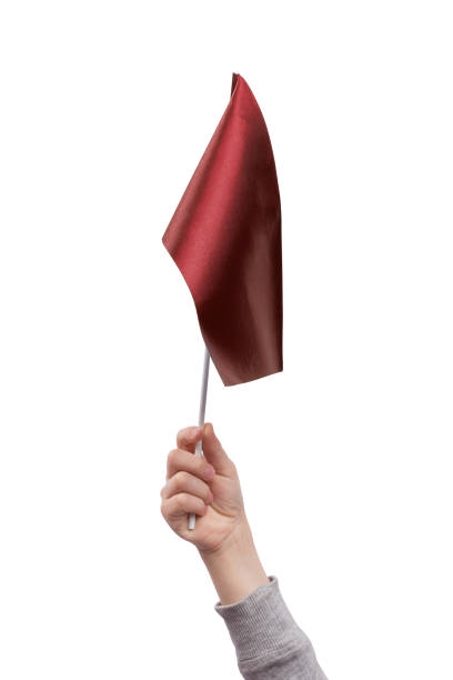 istock Childrens hand holding red flag isolated on white background. 1264868379