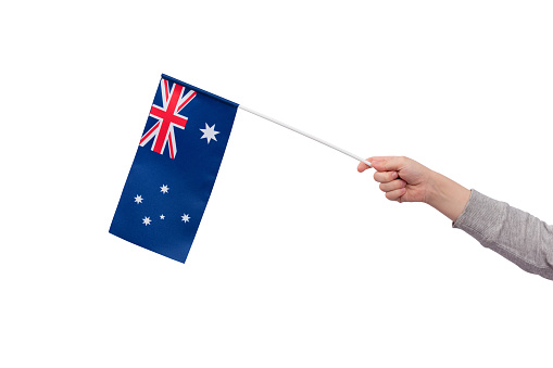 Childrens hand holds flag of Australia isolated on white background