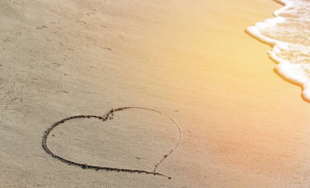 istock The heart is drawn on a sandy beach. Romantic picture on vacation. 1264868563