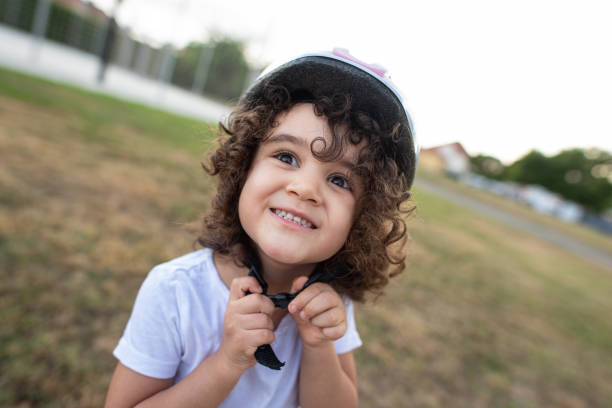 istock little girl putting her helmet. 1264868686