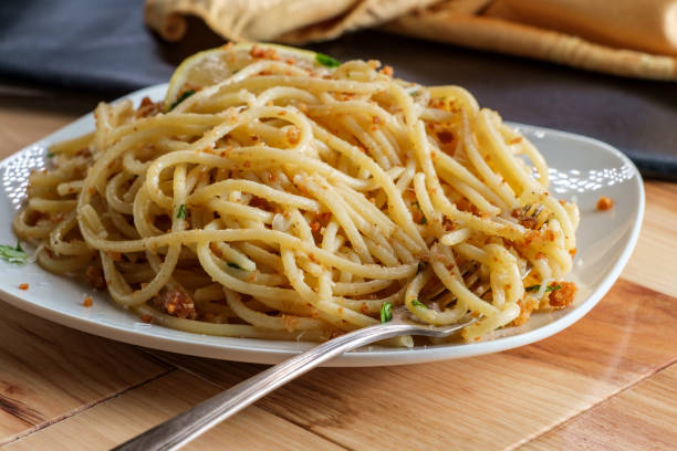 Italian Spaghetti Pasta Mollicata Italian spaghetti pasta mollicata with breadcrumbs parmesan cheese in an anchovy white wine sauce pecorino romano stock pictures, royalty-free photos & images