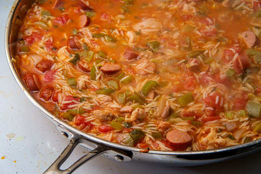Cooking Creole pot of chicken and andouille sausage Jambalaya with rice