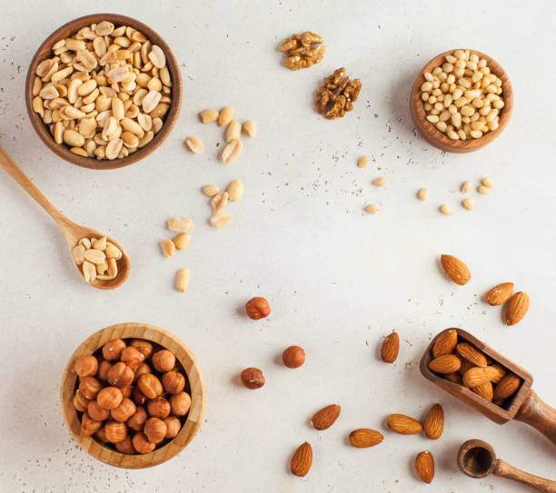 Text frame made of different nuts in wooden bowls. Nuts. Healthy snack. Copy space.