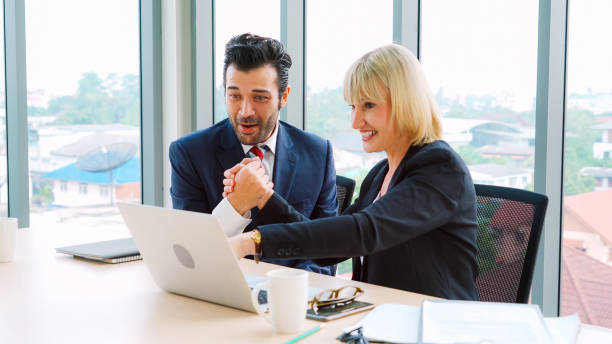 istock Two happy business people celebrate at office 1264872892
