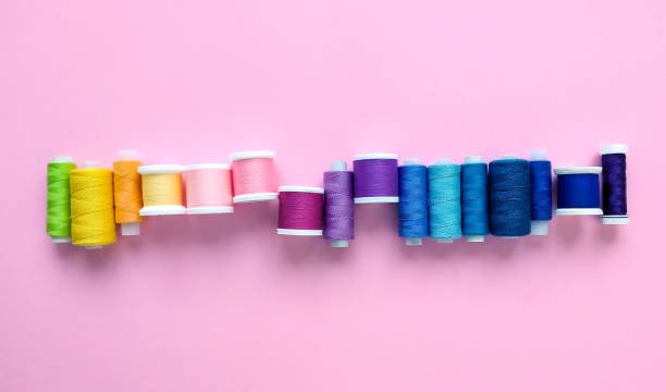 istock Flat lay composition of sewing threads on color pink background. Space for text. 1264873095
