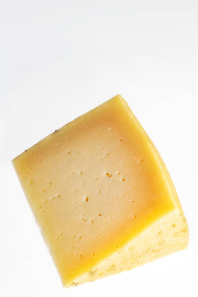 istock portion of cured manchego cheese on white background. Vertical shot 1264874881