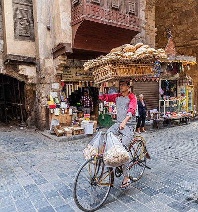 Fresh bread delivery to a vendor in the historic Khan el-Khalili Souk, Cairo, Egypt