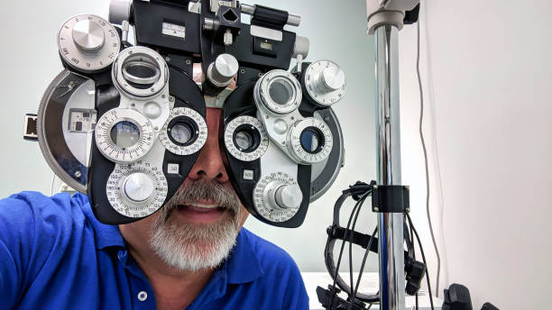 istock Man with goatee wearing blue shirt gets eye exam with diopter machine 1264879419