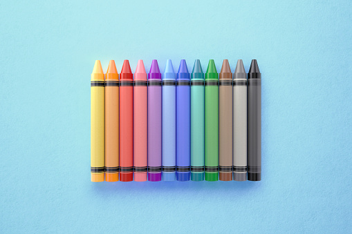 Multicolored crayons lined up on white background. Group of crayons of different colors.