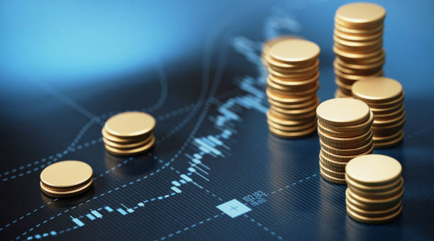 coin stacks sitting on a blue financial graph background - save costs imagens e fotografias de stock