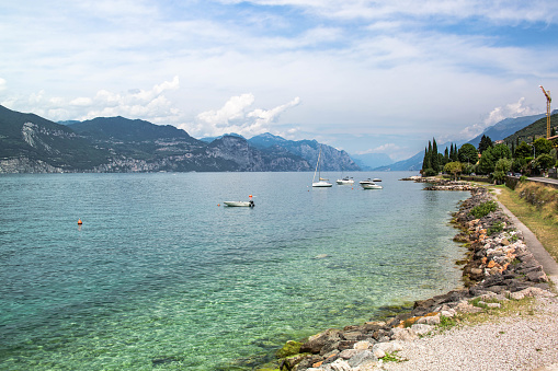 beach at lake garda, Italy, blue ant turquoise water, mountains and boats