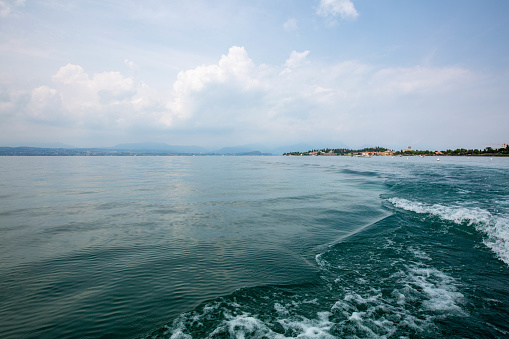 panorama of Island at lake garda, Italy, boat view with blue water and cloudy sky