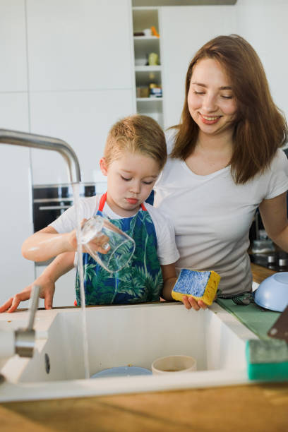 istock mother and son wash dishes together 1264890360