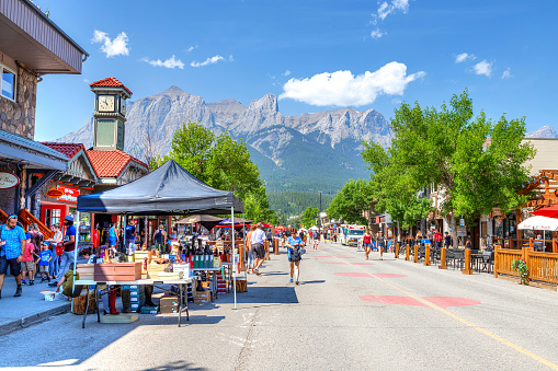 Tourists walk along popular downtown Canmore in the Canadian Rockies. The road was closed to traffic due to COVID-19 to allow for more social distancing among visitors.