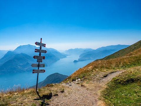 Trail signs on a path in the alps of Lake Como