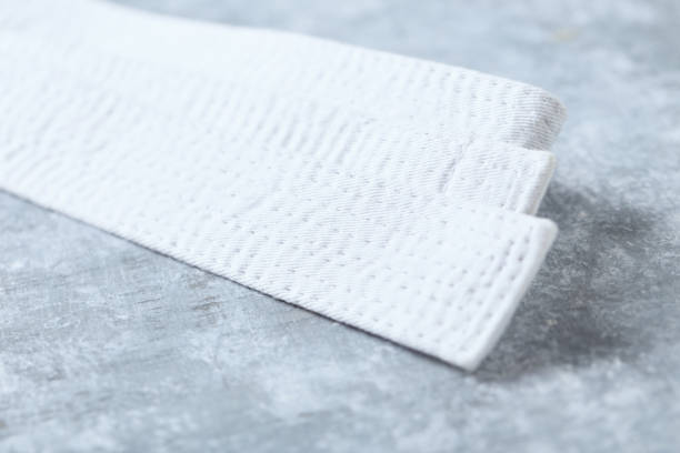 istock White karate belt on rustic wooden background. Close up. Copy space. 1264894661