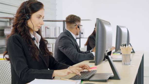 istock Business people wearing headset working in office 1264897985