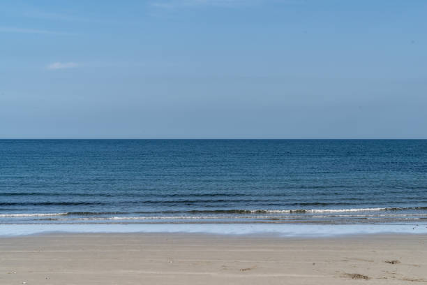 Sandy beach, waves crashing and horizon over Irish Sea.  Quintin Bay, County Down, Northern Ireland.