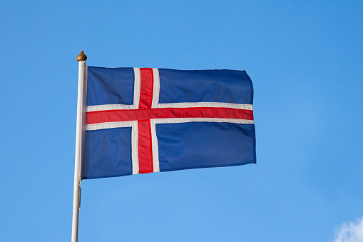 Iceland flag is is isolated on blue sky background. Outdoor.