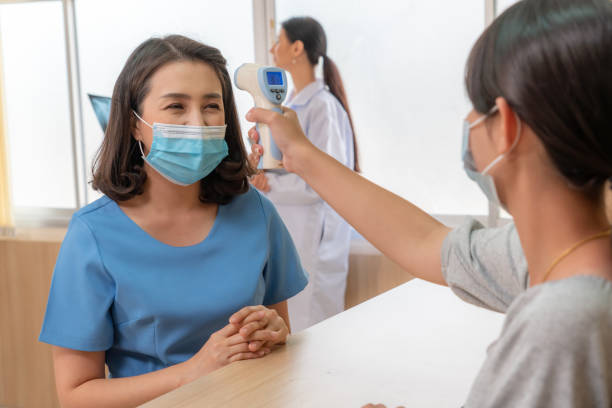 istock Receptionist and guest wearing face mask at front desk . 1264910373