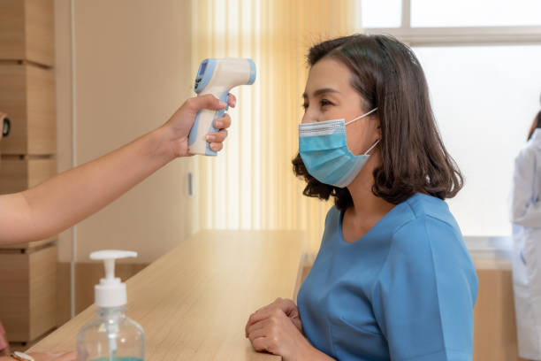 istock Receptionist and guest wearing face mask at front desk . 1264911127