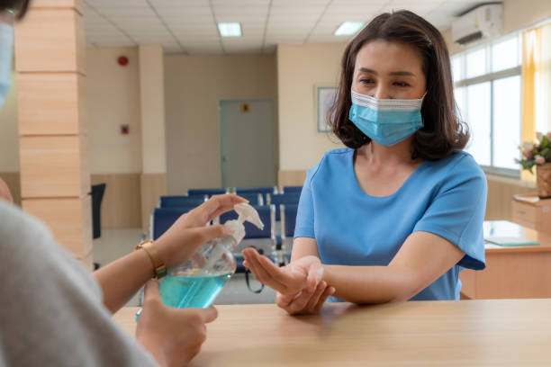 istock Receptionist and guest wearing face mask at front desk . 1264912562