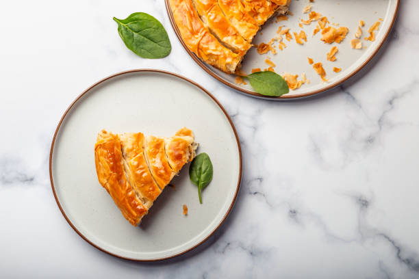 Filo Spinach and Feta Twist Pie Filo Spinach and Feta Twist Pie in the iron pan after oven. Authentic Greek bakery. With spinach, mizithra and feta cheeses. spanakopita stock pictures, royalty-free photos & images