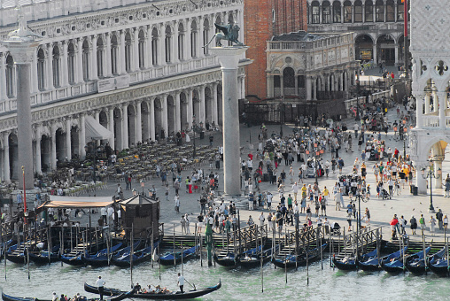 A wonderful aerial panoramic view of hundreds of people enjoying famously beautiful St. Mark's square in Venice, Italy.