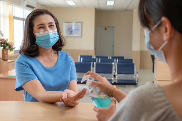 Receptionist and guest wearing face mask at front desk .