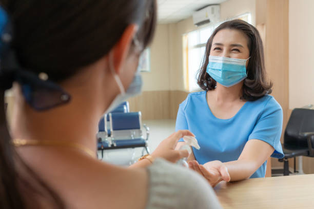 istock Receptionist and guest wearing face mask at front desk . 1264917285